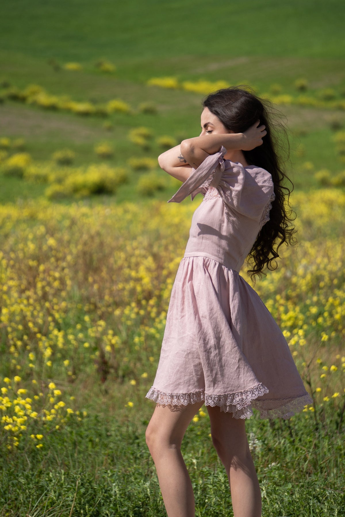 April antique pink linen mini dress, side view among wildflowers
