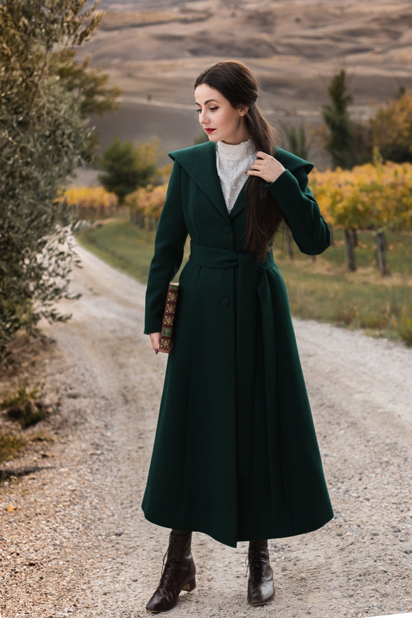 Arwen emerald green hooded wool coat, full-length front view on a country road among autumn vineyards