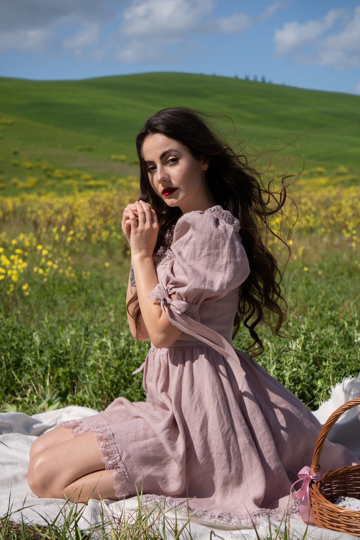 April antique pink linen mini dress with puff sleeves, seated on a picnic blanket