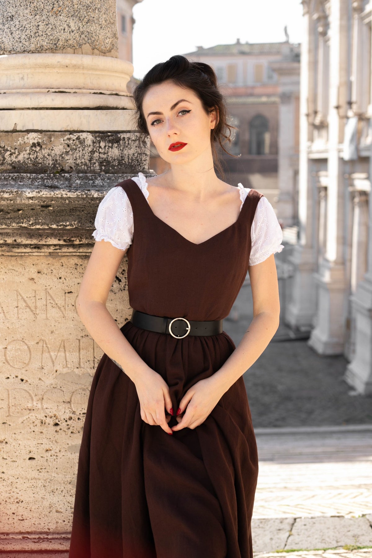 Close-up of the Andalusia dark brown linen dress: sweetheart neckline and gathered waist with a black belt
