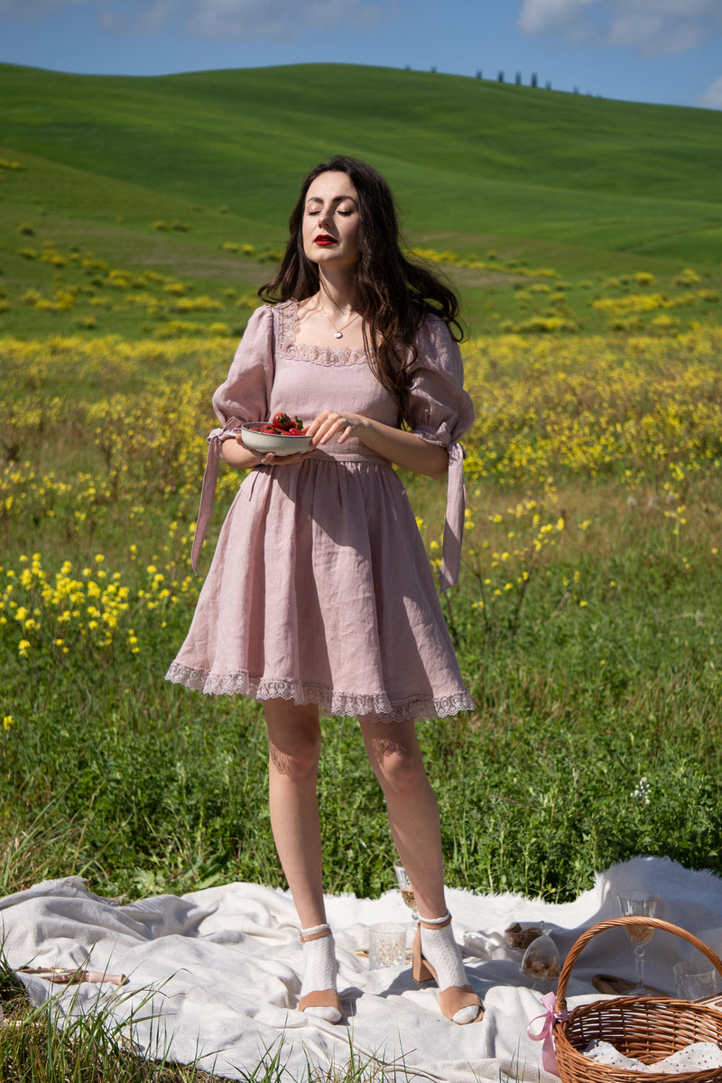 April antique pink linen mini dress with a flared skirt, front view in green rolling hills