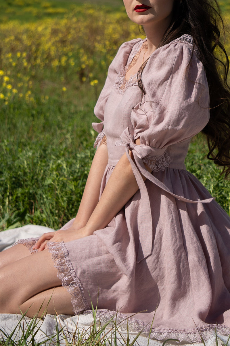 Close-up of the April antique pink linen dress with a bow at the puff sleeve and lace details