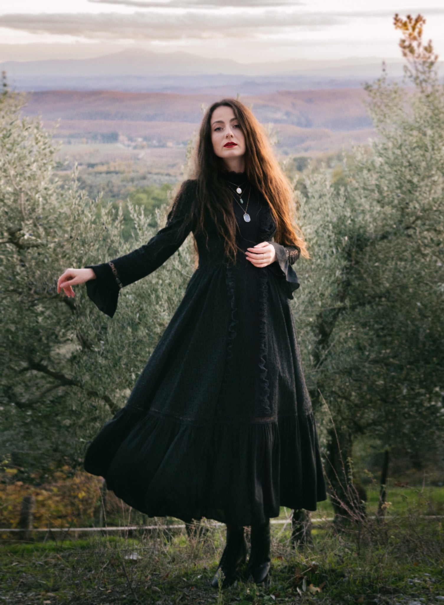 girl in dark and moody olive grove wearing black maxi dress