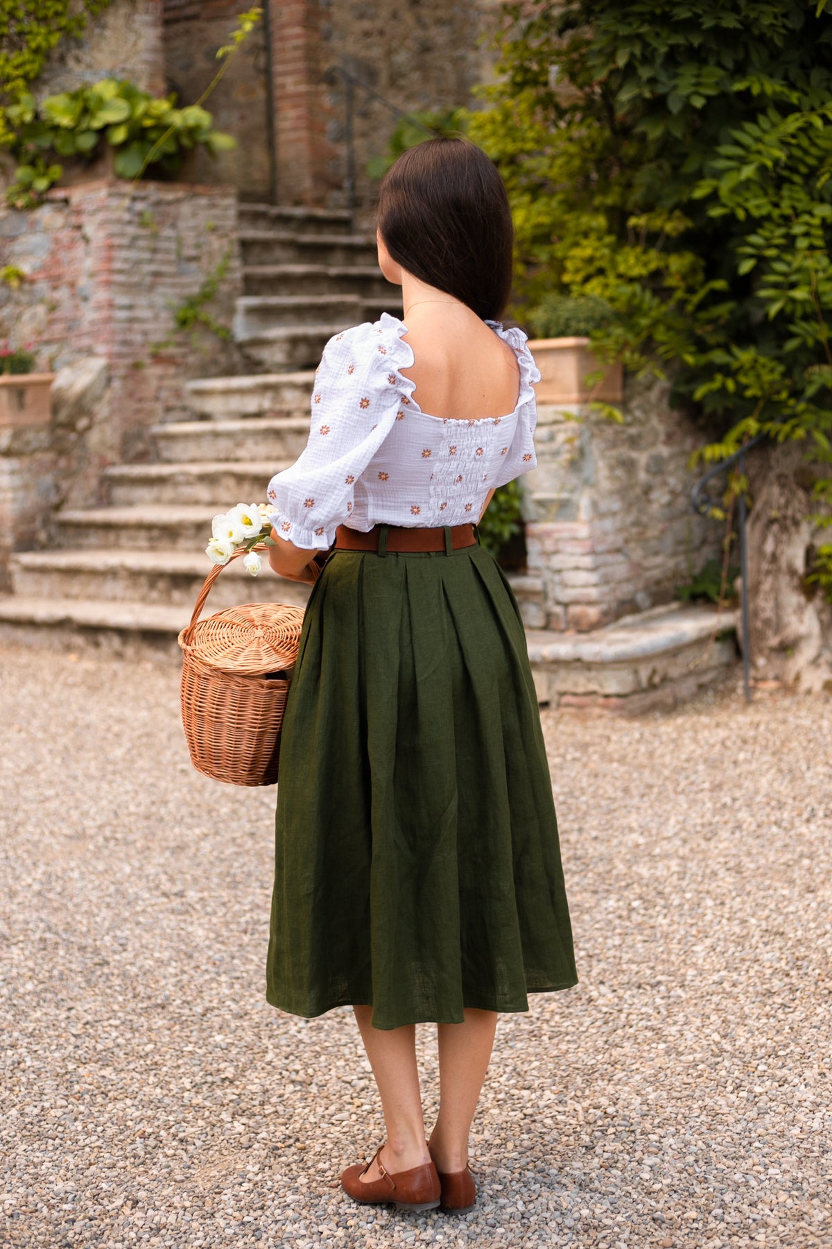 Back view of the Ivy moss green pleated linen midi skirt with an elastic back waistband