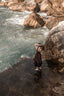 Andalusia dark brown linen dress with a dramatic full skirt photographed among coastal rocks