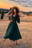 Full-length view of the Andalusia emerald green linen dress photographed in a countryside field at sunset
