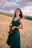 Three-quarter view of the Andalusia emerald green linen dress with a fitted sweetheart bodice.