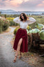 Ellie burgundy linen midi skirt with a front slit styled with a white blouse in the countryside