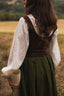 Back view of the Estella dark brown linen corset styled with a white blouse and moss green skirt