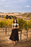 Three-quarter vineyard view of the Estella moss green linen corset styled with a white blouse and dark skirt