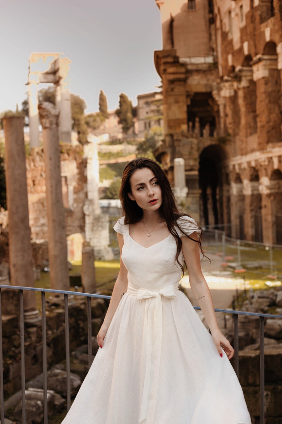 Bianka milky white 1950s linen dress with cap sleeves and a tie sash, among ancient ruins