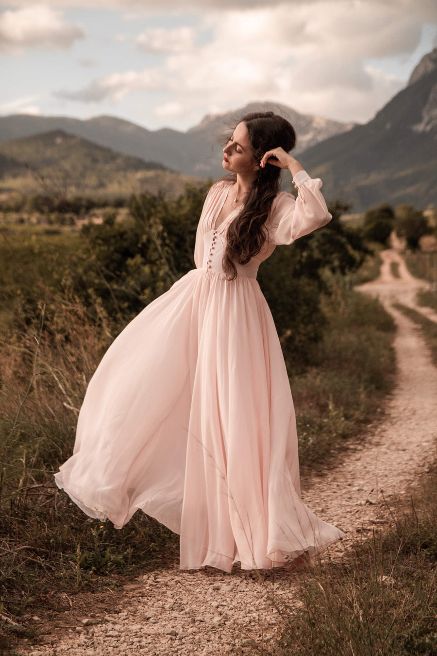 Moonlight in Marrakesh blush pink silk georgette maxi dress with long sheer sleeves, on a mountain path