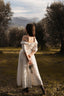 Back view of the Under the Tuscan Sky ivory linen wedding dress photographed among olive trees