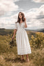 Full-length front view of the Under the Tuscan Sky ivory linen wedding dress in the countryside