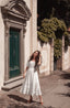 Under the Tuscan Sky ivory linen wedding dress photographed on a historic Italian village street